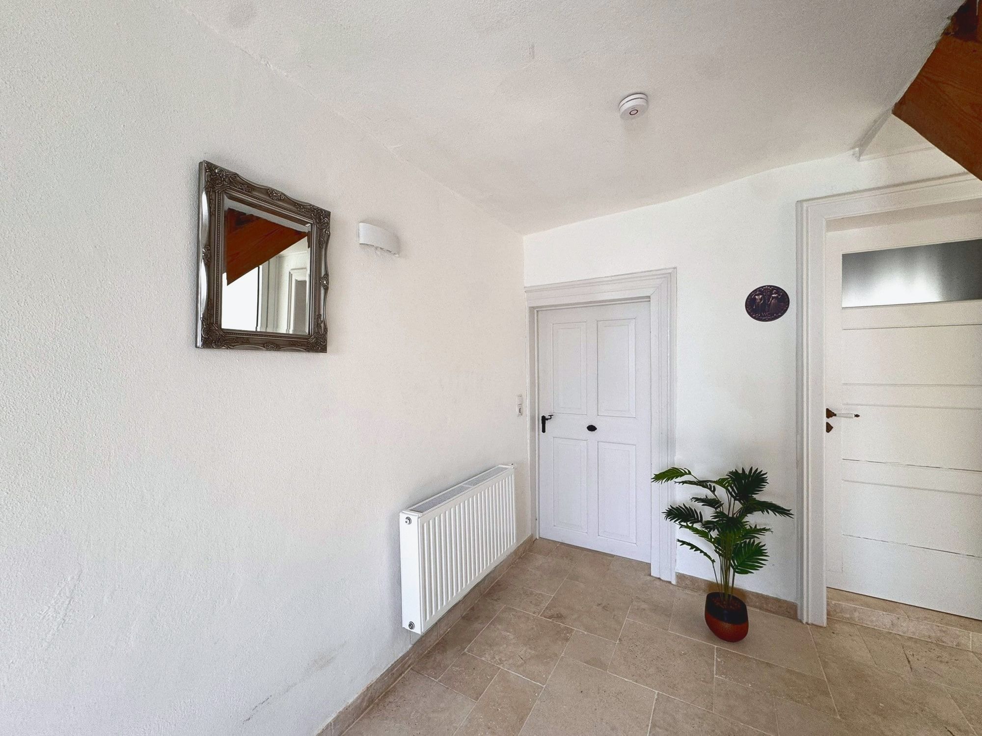 Heller Hausflur mit Spiegel und Natursteinboden