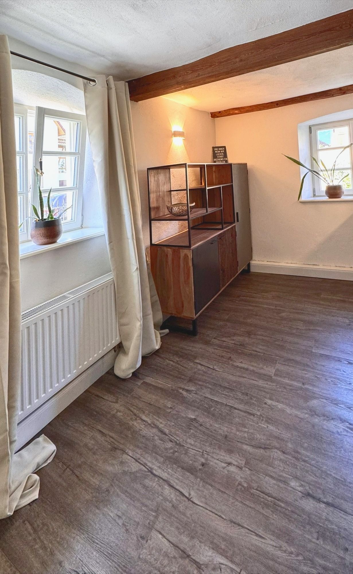 Küche mit Holz-Sideboard, Wandleuchte und zwei Fenstern