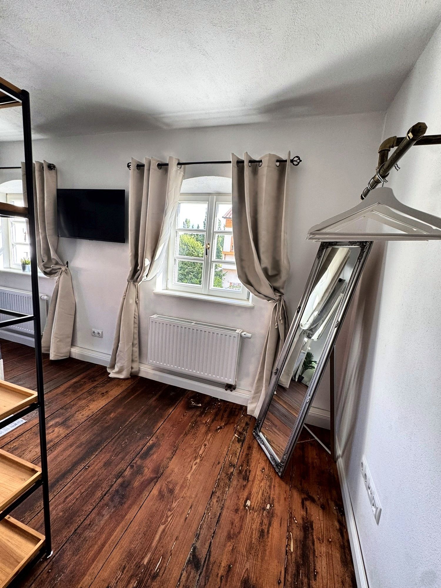 Schlafzimmer 1 mit Sprossenfenstern, Smart TV, Standspiegel und Kleiderstange