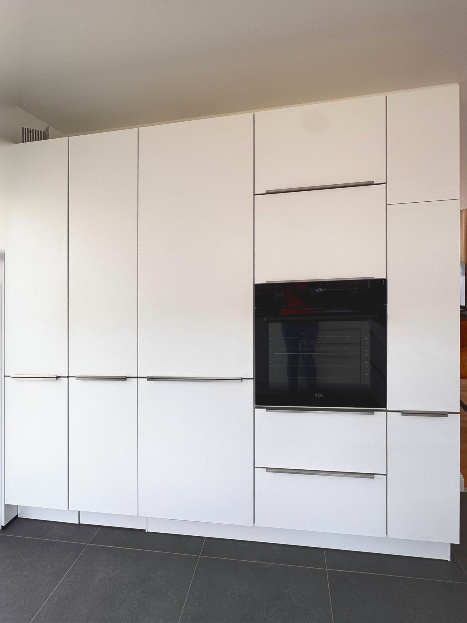Küchenzeile mit Backofen, Kühlschrank und Hochschränken