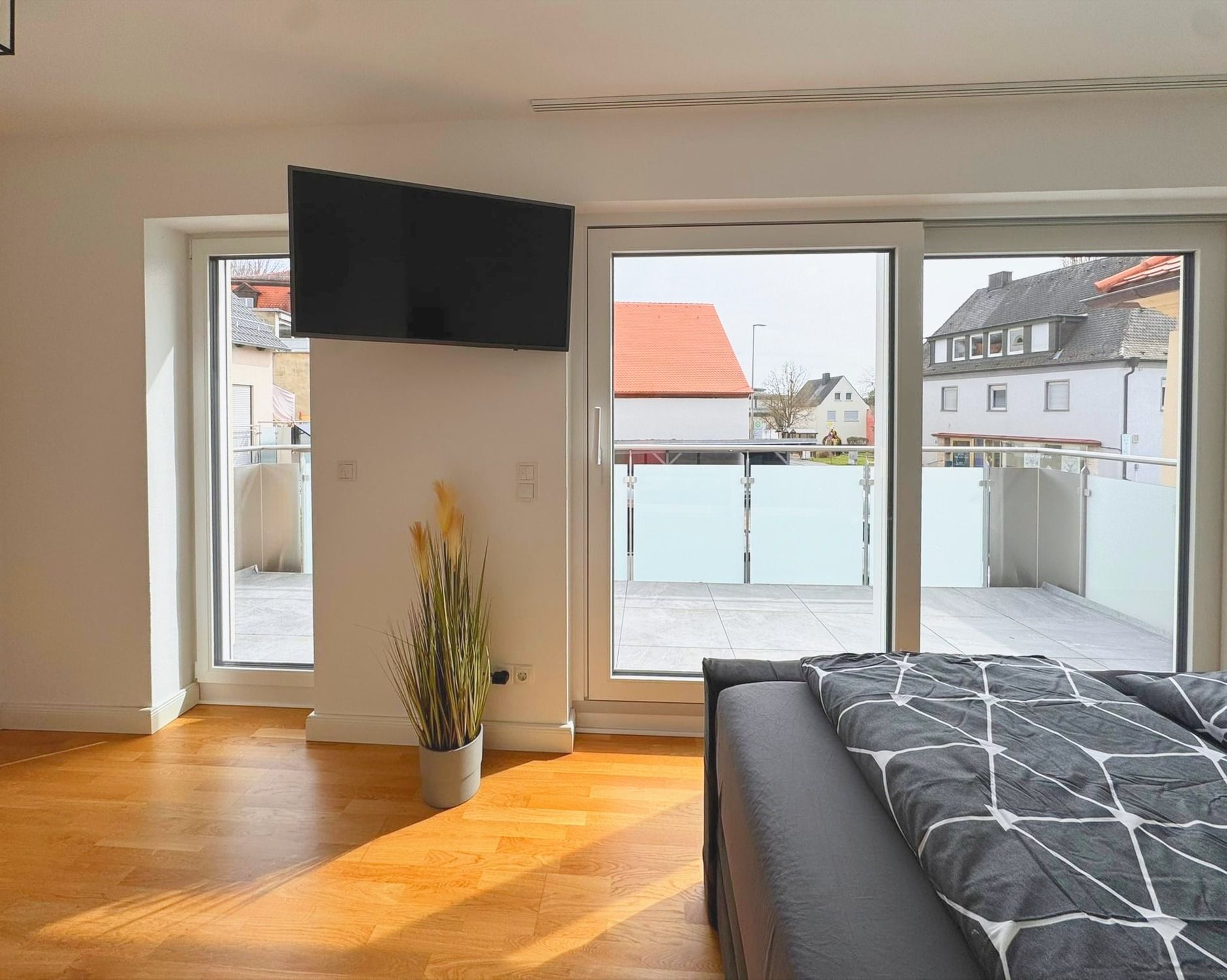 Schlafzimmer 1 mit Smart TV und Tür zum Balkon