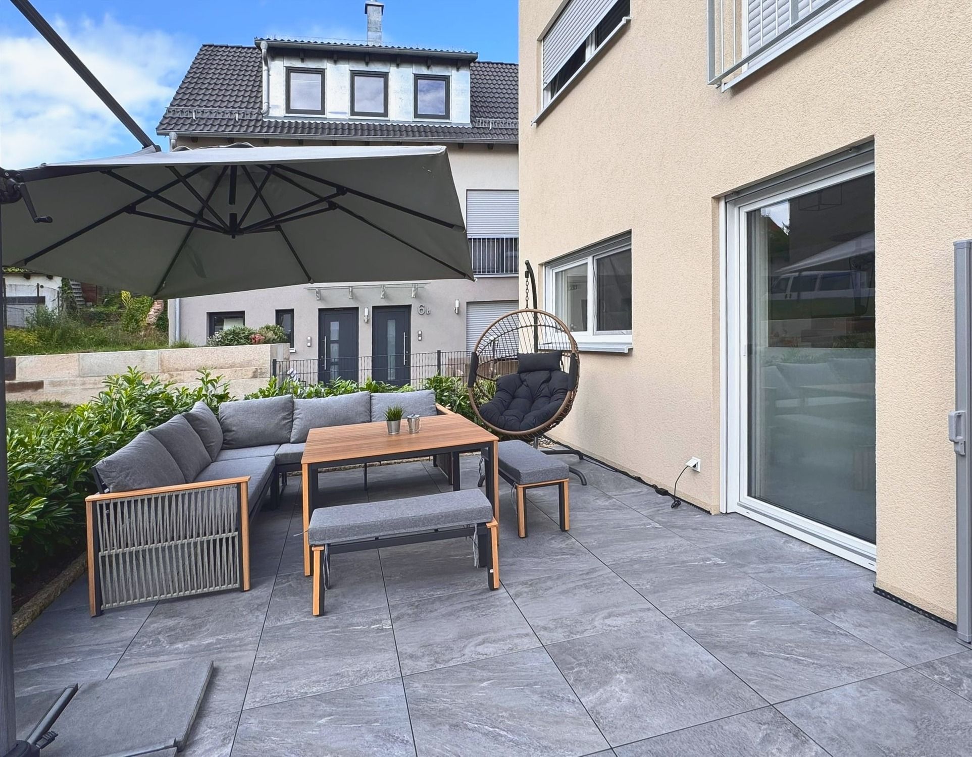 Terrasse mit Lounge, Hängesessel und Sonnenschirm